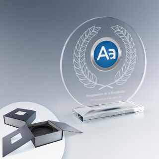Trophée rond en verre sur socle, avec gravure laser et logo en couleur, présenté à côté de son écrin noir ouvert.