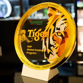 Grande médaille en verre cerclée de métal doré, personnalisée avec un tigre en couleur et présentée sur un support.