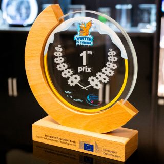 Trophée bi-matière en bois et verre rond sur socle, personnalisé avec la mention « 1er prix » et des logos couleur.