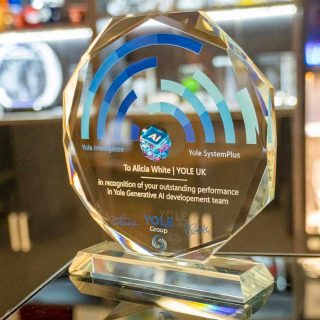Trophée Sunflower en verre facetté sur socle, personnalisé avec des motifs bleus, le logo Yole Group et une dédicace nominative.